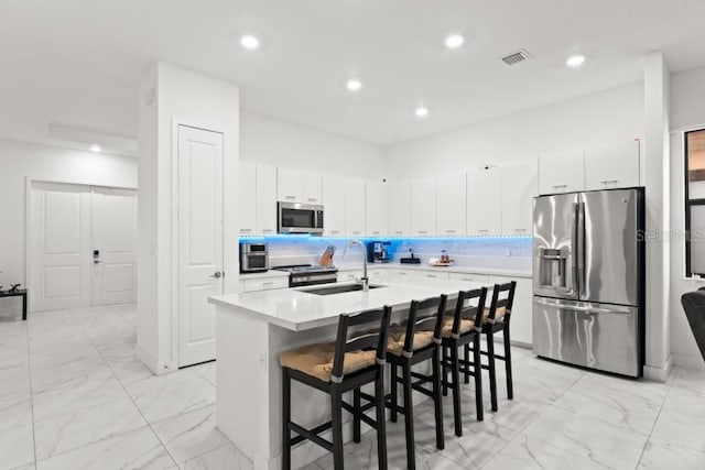 4445 SW 173rd Ave, Miramar, FL 33029 - kitchen featuring appliances with stainless steel finishes, a sink, light marble finish floors, a breakfast bar, and recessed lighting