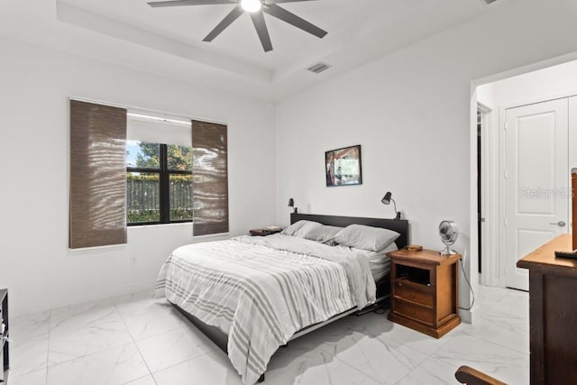 4445 SW 173rd Ave, Miramar, FL 33029 - bedroom with light marble finish flooring, a tray ceiling, and a ceiling fan