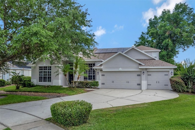 12411 Scarlett Sage Ct, Winter Garden, FL 34787 - ranch-style home featuring an attached garage, stucco siding, solar panels, concrete driveway, and a front yard