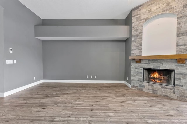 12411 Scarlett Sage Ct, Winter Garden, FL 34787 - unfurnished living room featuring wood finished floors, a stone fireplace, and baseboards