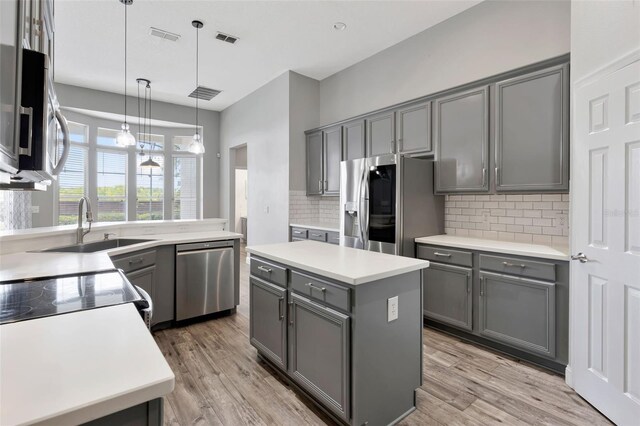 12411 Scarlett Sage Ct, Winter Garden, FL 34787 - kitchen featuring appliances with stainless steel finishes, gray cabinets, and decorative backsplash