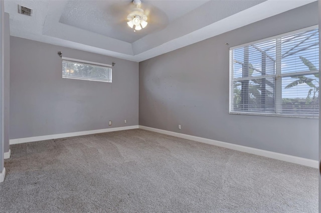 12411 Scarlett Sage Ct, Winter Garden, FL 34787 - carpeted empty room with a tray ceiling, plenty of natural light, ceiling fan, and baseboards