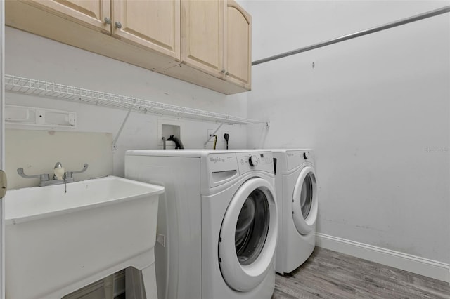 12411 Scarlett Sage Ct, Winter Garden, FL 34787 - clothes washing area featuring cabinet space, light wood-style floors, washer and dryer, and baseboards