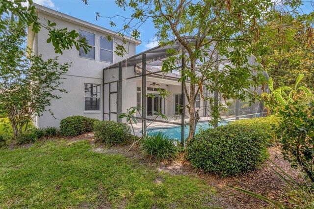 12411 Scarlett Sage Ct, Winter Garden, FL 34787 - back of house with stucco siding, a ceiling fan, a patio area, an outdoor pool, and glass enclosure