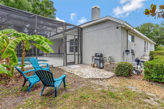 12411 Scarlett Sage Ct, Winter Garden, FL 34787 - back of property featuring a patio, a chimney, an outdoor pool, stucco siding, and glass enclosure