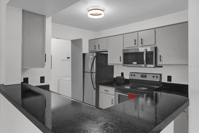 kitchen featuring appliances with stainless steel finishes, washer / clothes dryer, a peninsula, and gray cabinets