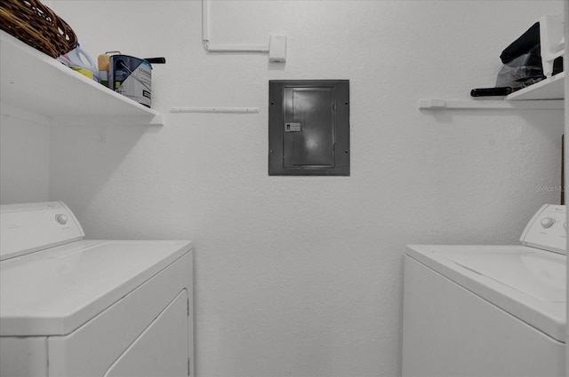 clothes washing area featuring electric panel and washer and clothes dryer