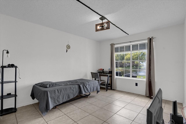 bedroom with light tile patterned flooring and a textured ceiling