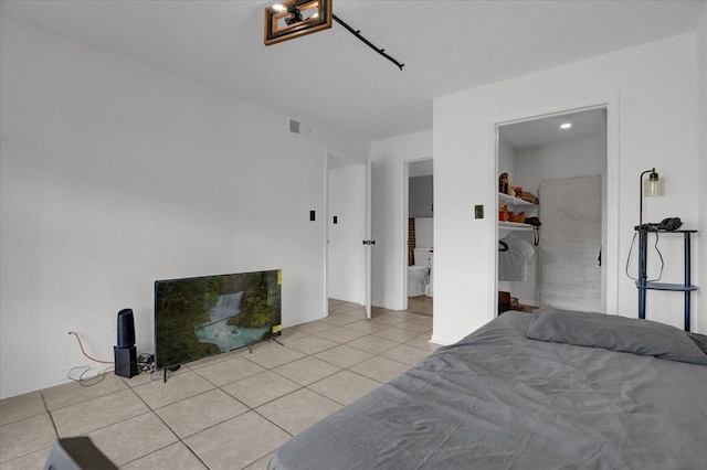 bedroom with tile patterned floors and ensuite bath