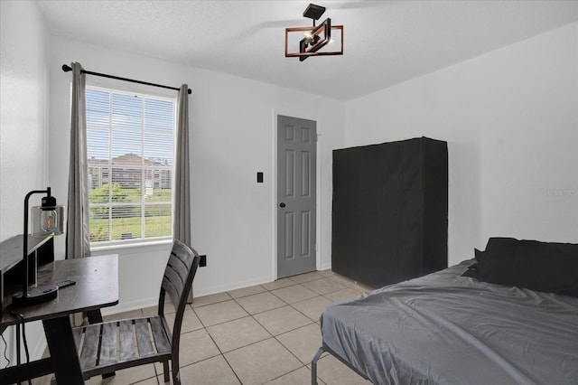 bedroom with light tile patterned floors and baseboards