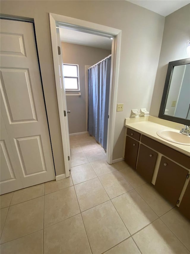 bathroom with tile patterned floors, vanity, and baseboards