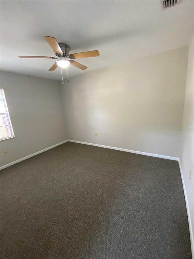 carpeted empty room with a ceiling fan and baseboards
