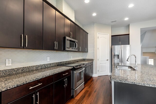 625 Pavia Loop, Lake Mary, FL 32746 - kitchen with stainless steel appliances, a sink, stone counters, dark wood-type flooring, and backsplash