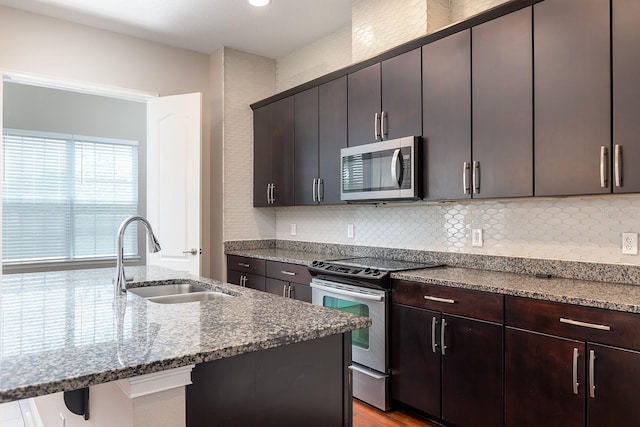 625 Pavia Loop, Lake Mary, FL 32746 - kitchen with appliances with stainless steel finishes, a sink, tasteful backsplash, and dark stone counters