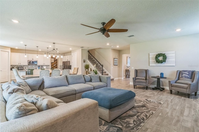 2539 Auburn Ridge Dr, Apopka, FL 32712 - living room with light wood-type flooring, ceiling fan, recessed lighting, baseboards, and stairs