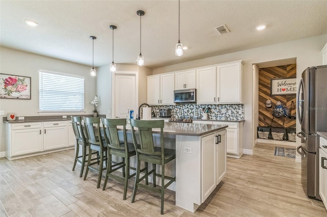 2539 Auburn Ridge Dr, Apopka, FL 32712 - kitchen featuring stainless steel appliances, decorative backsplash, white cabinetry, light wood-style flooring, and recessed lighting