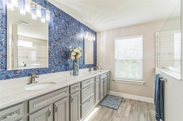 2539 Auburn Ridge Dr, Apopka, FL 32712 - bathroom featuring baseboards, wood finished floors, double vanity, and wallpapered walls