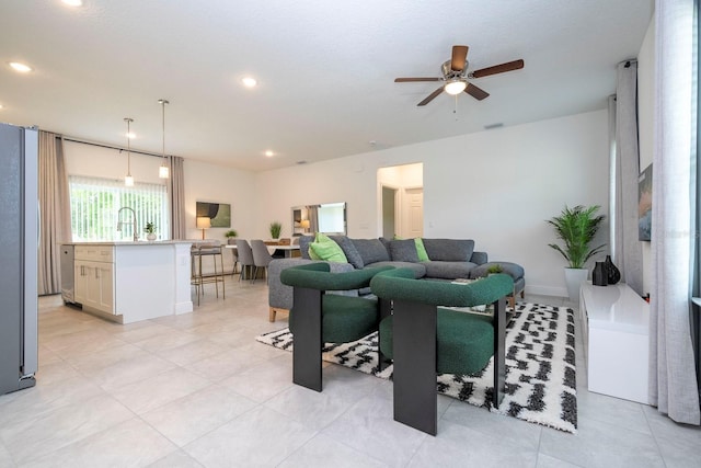 living room with a ceiling fan, recessed lighting, and light tile patterned flooring