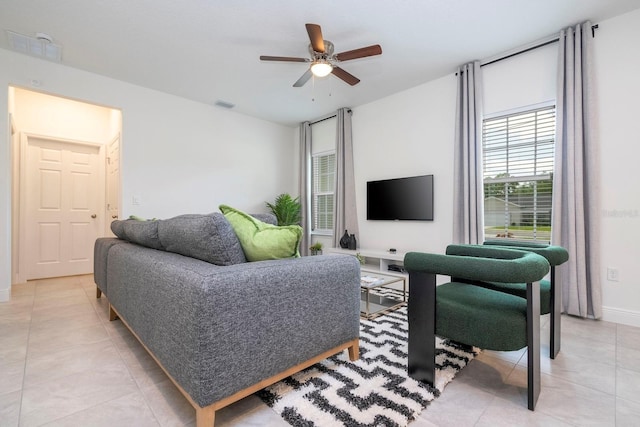 living room featuring light tile patterned floors, a ceiling fan, and baseboards