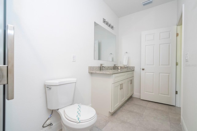 bathroom with toilet, tile patterned flooring, vanity, and baseboards