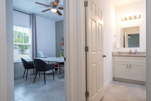 bathroom with a ceiling fan, baseboards, vanity, and tile patterned flooring