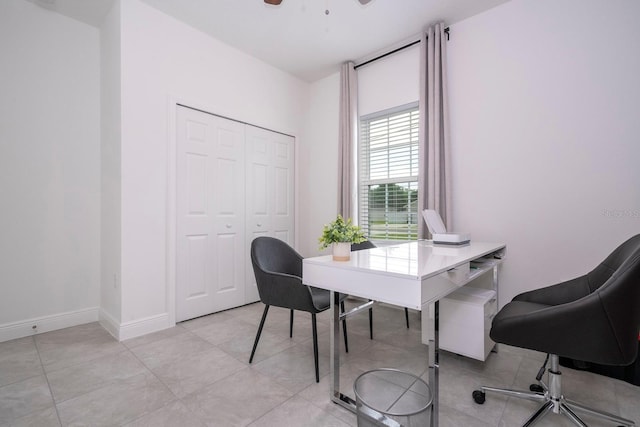 office space with baseboards, light tile patterned floors, and ceiling fan