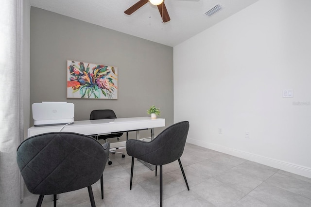 office space featuring a ceiling fan and baseboards