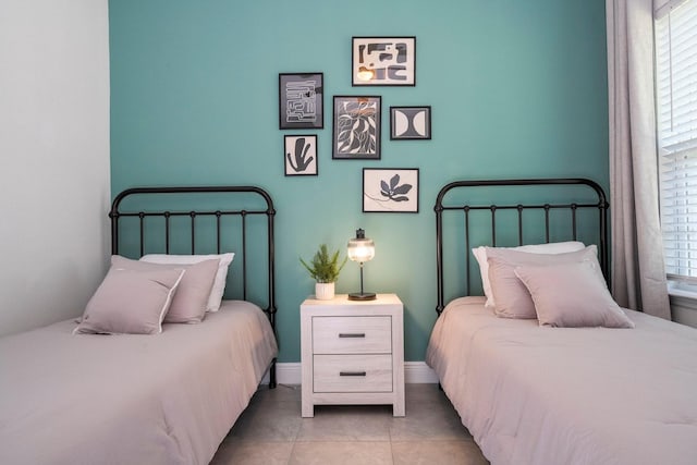 tiled bedroom featuring baseboards