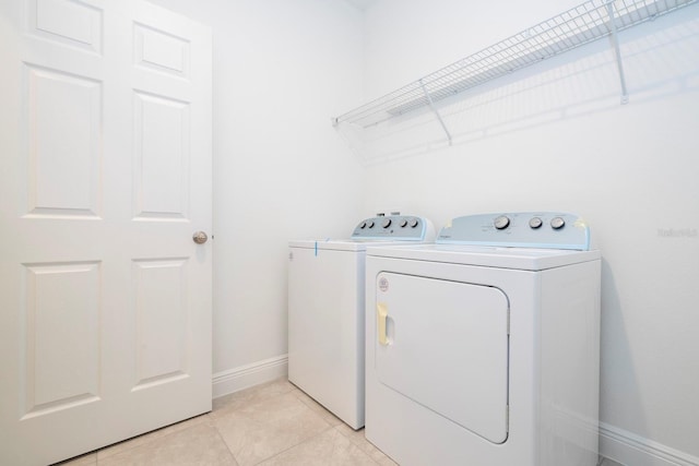 laundry room with independent washer and dryer, baseboards, and light tile patterned floors