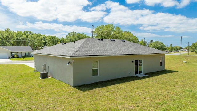 back of house featuring a yard, stucco siding, a shingled roof, and cooling unit
