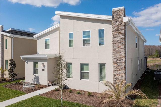 2836 Simile St, Kissimmee, FL 34746 - view of front of home featuring stucco siding, a chimney, and stone siding