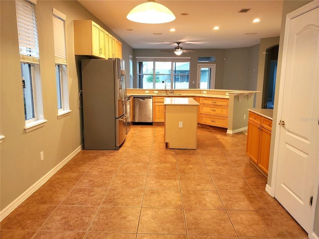kitchen featuring appliances with stainless steel finishes, light countertops, a sink, a center island, and recessed lighting