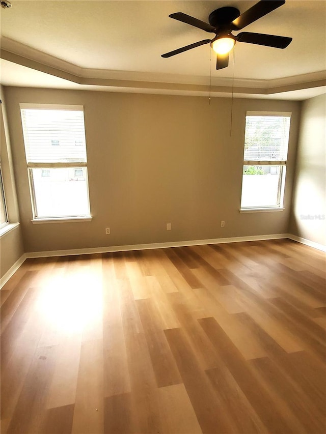 spare room featuring light wood-style floors, baseboards, and ceiling fan