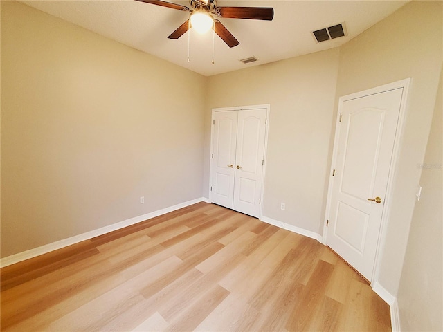 unfurnished bedroom featuring light wood-style flooring, baseboards, a closet, and a ceiling fan