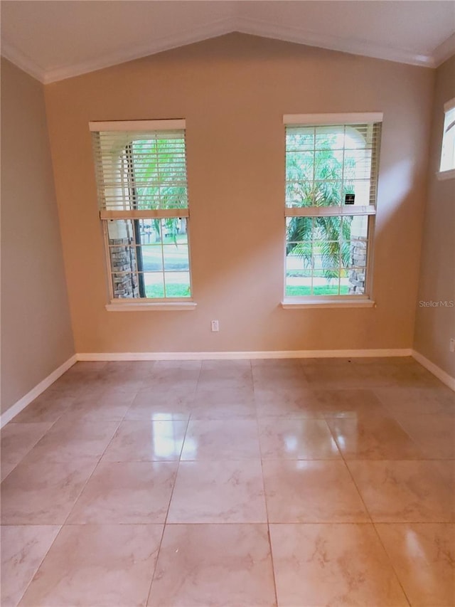 spare room with ornamental molding, lofted ceiling, and baseboards