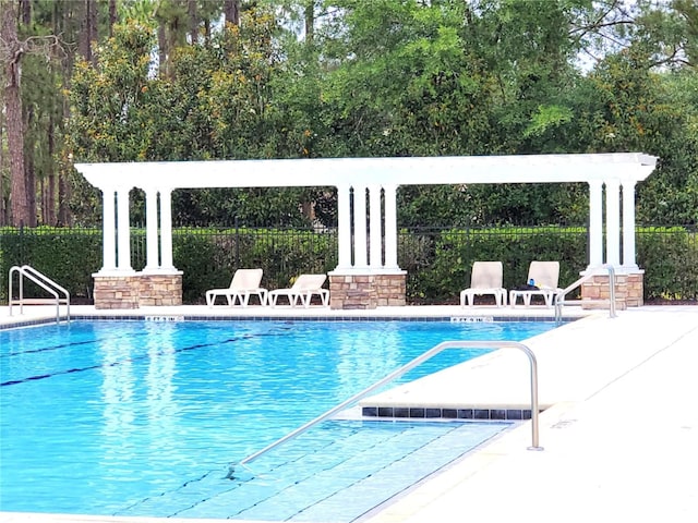 community pool featuring fence and a patio area