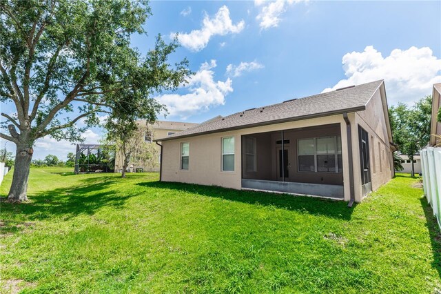 6728 Duncaster St, Windermere, FL 34786 - rear view of property featuring a sunroom, a lawn, and stucco siding