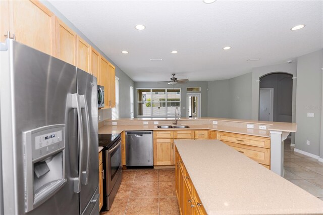 6728 Duncaster St, Windermere, FL 34786 - kitchen with stainless steel appliances, a sink, light brown cabinets, recessed lighting, and a peninsula