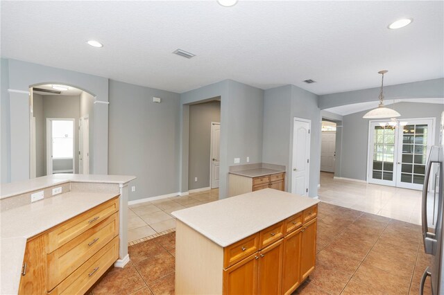 6728 Duncaster St, Windermere, FL 34786 - kitchen with arched walkways, a kitchen island, light tile patterned floors, light countertops, and recessed lighting