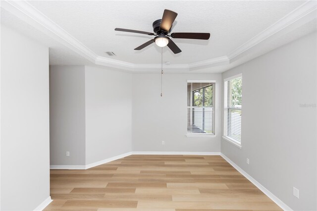 6728 Duncaster St, Windermere, FL 34786 - empty room featuring a tray ceiling, a ceiling fan, ornamental molding, light wood-style floors, and baseboards