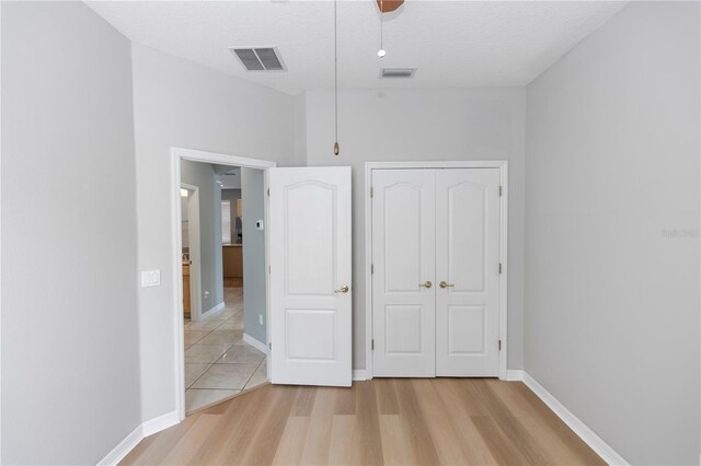 6728 Duncaster St, Windermere, FL 34786 - unfurnished bedroom with light wood finished floors, a closet, baseboards, and a ceiling fan