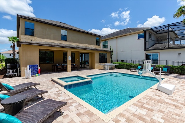 view of pool with a patio area, a pool with connected hot tub, and fence