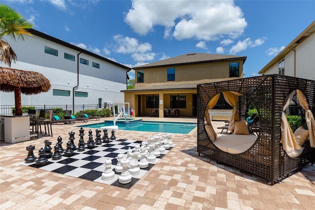 view of swimming pool with fence, a patio, and a pool with connected hot tub