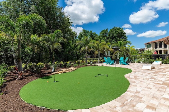 surrounding community with a putting area, fence, and a patio