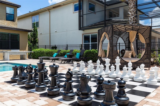 view of community featuring fence, a pool, and a patio