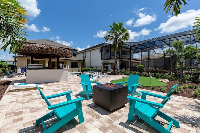 view of patio with a putting area, a bar, and an outdoor fire pit
