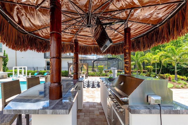 view of patio with grilling area, exterior kitchen, fence, and outdoor dining space