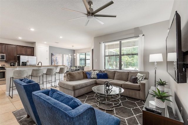 living area featuring ceiling fan, light tile patterned flooring, a textured ceiling, and recessed lighting