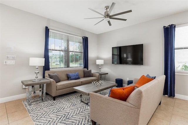 living room with light tile patterned floors, ceiling fan, and baseboards