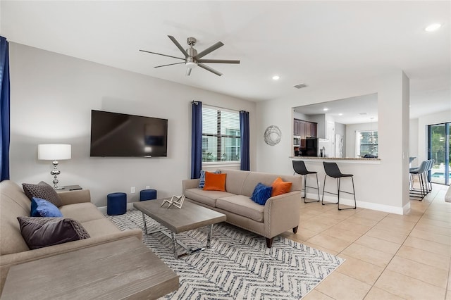 living area featuring light tile patterned flooring, ceiling fan, recessed lighting, and baseboards